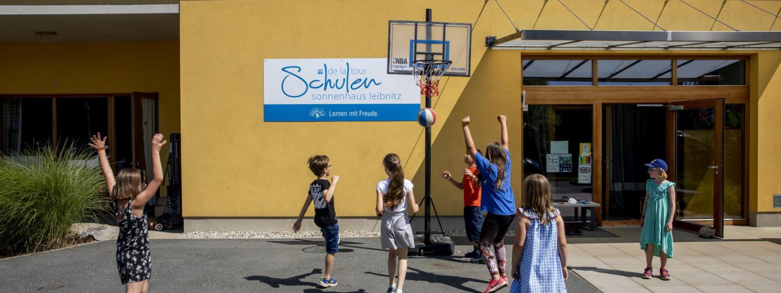 Kinder spielen vor der Schule